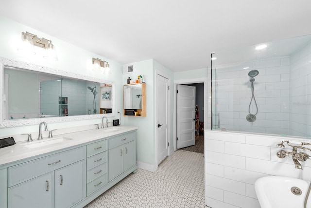 full bath with double vanity, visible vents, tiled shower, and a sink