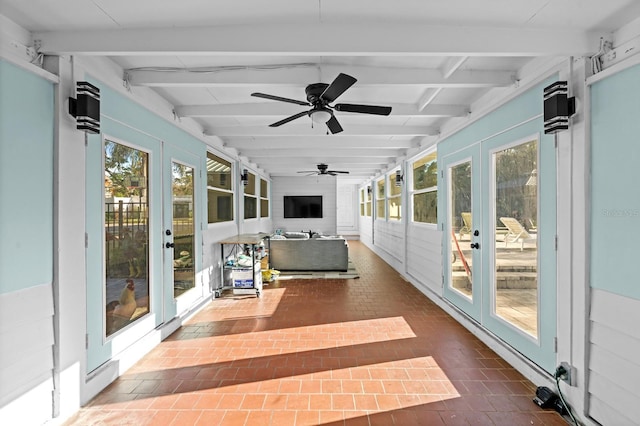 sunroom featuring beamed ceiling, ceiling fan, french doors, and brick floor