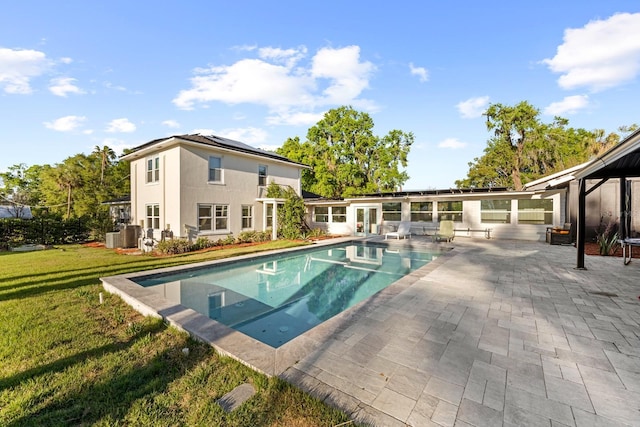outdoor pool featuring french doors, a yard, and a patio area