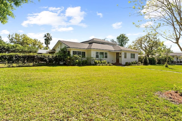 view of front of house with stucco siding, fence, and a front yard