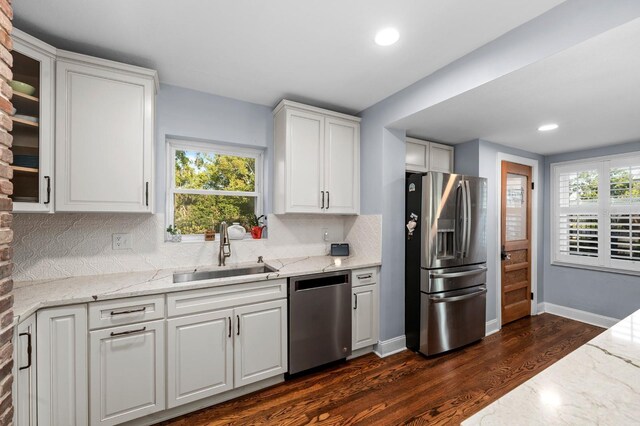 kitchen with white cabinetry, a healthy amount of sunlight, dark wood-style flooring, stainless steel appliances, and a sink