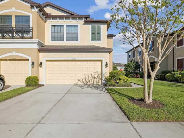 view of front of property with stucco siding, an attached garage, concrete driveway, and a front lawn