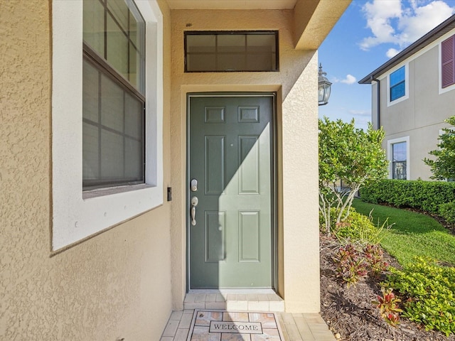 entrance to property featuring stucco siding