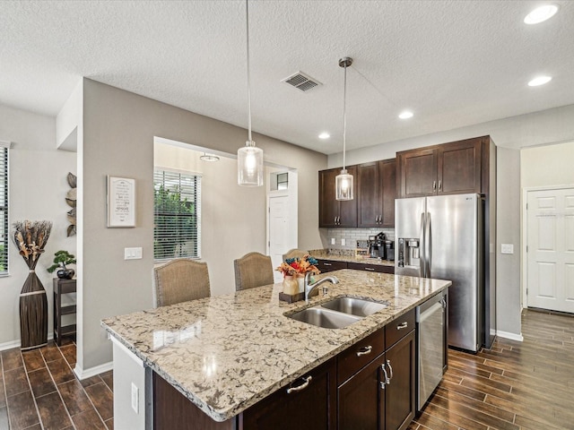 kitchen with a sink, dark brown cabinetry, appliances with stainless steel finishes, and wood tiled floor