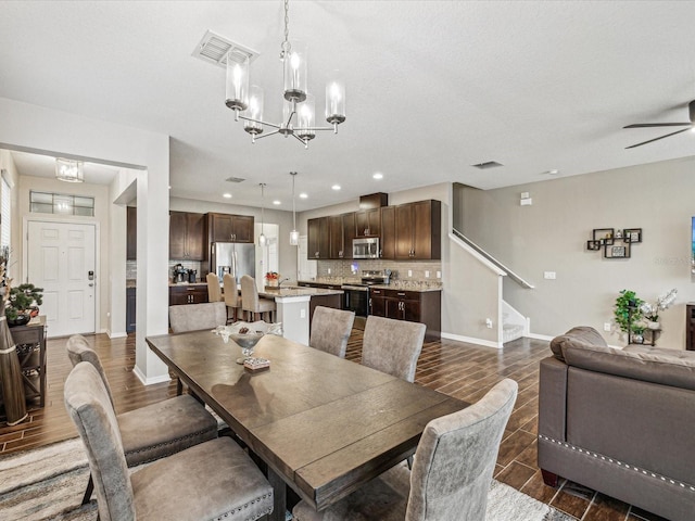 dining room with visible vents, baseboards, wood tiled floor, and stairs