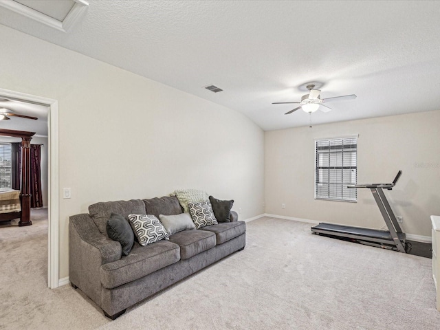 living room with a textured ceiling, light carpet, visible vents, and ceiling fan