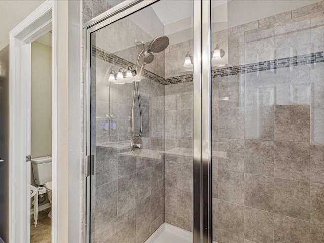 full bath featuring a shower stall and toilet