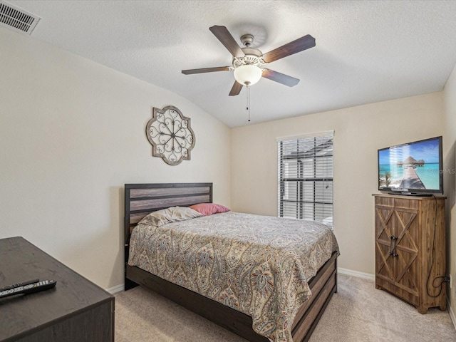 bedroom with a textured ceiling, light colored carpet, visible vents, and baseboards