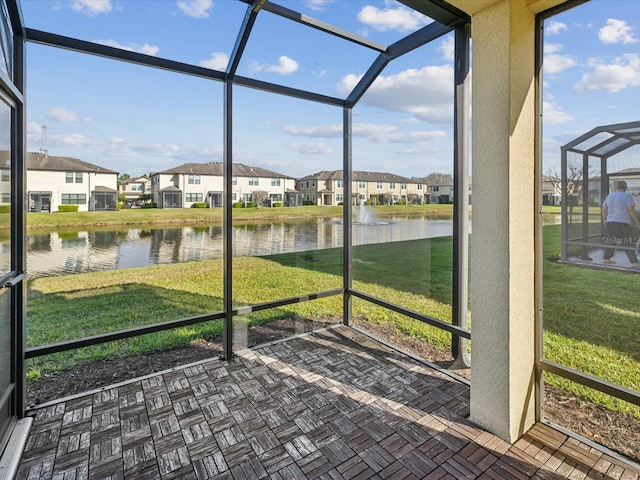 unfurnished sunroom with a water view and a residential view