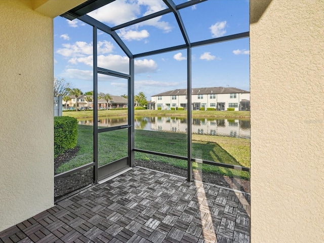 unfurnished sunroom with a residential view and a water view