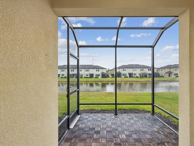 unfurnished sunroom featuring a residential view and a water view