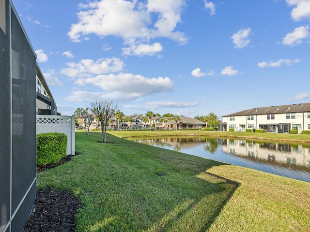 view of yard featuring a lanai, a water view, and a residential view