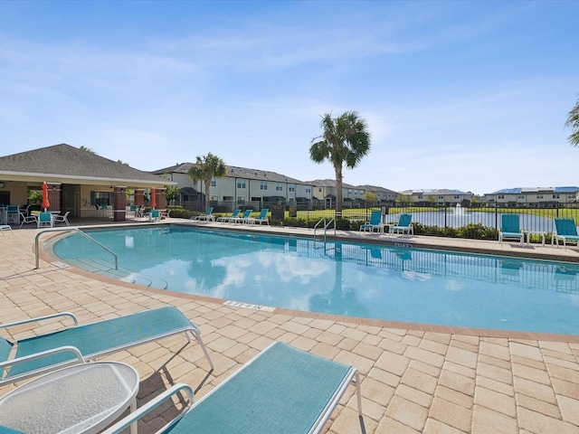 pool with a residential view, fence, and a patio area