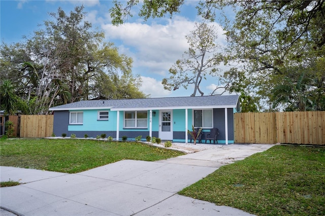 view of front of home with a porch, a front lawn, and fence