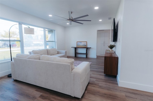 living room featuring plenty of natural light, recessed lighting, dark wood-style flooring, and baseboards