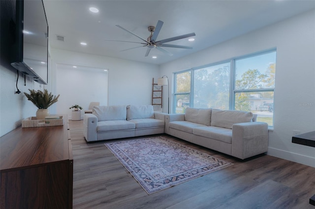 living room featuring a ceiling fan, wood finished floors, visible vents, baseboards, and recessed lighting