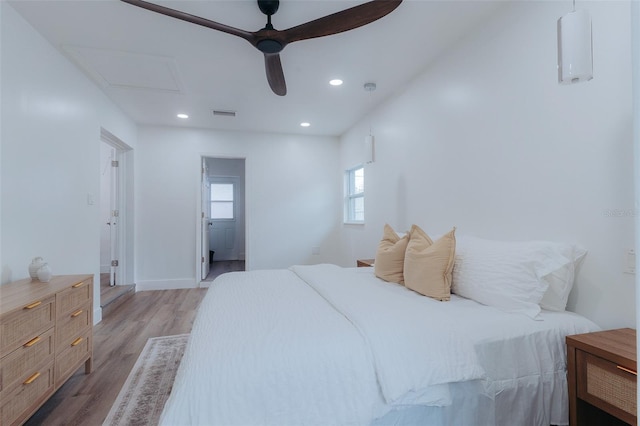 bedroom featuring light wood finished floors, visible vents, recessed lighting, and attic access