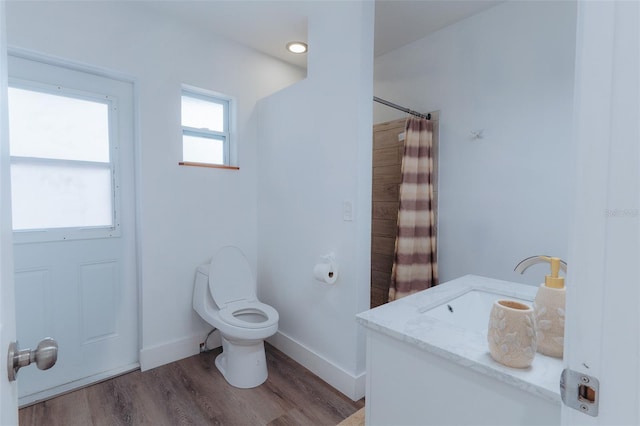 full bathroom featuring baseboards, toilet, a shower with curtain, wood finished floors, and vanity