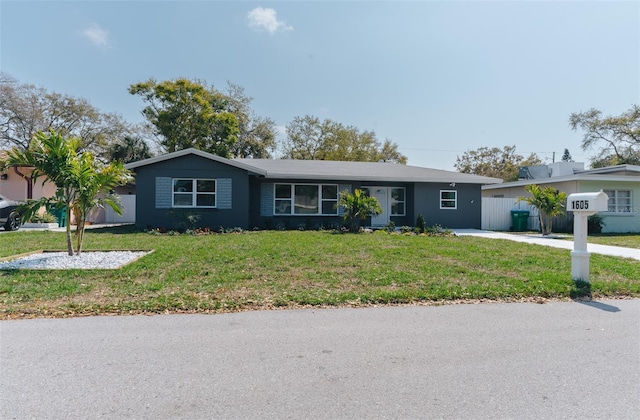 ranch-style home with a front lawn and fence