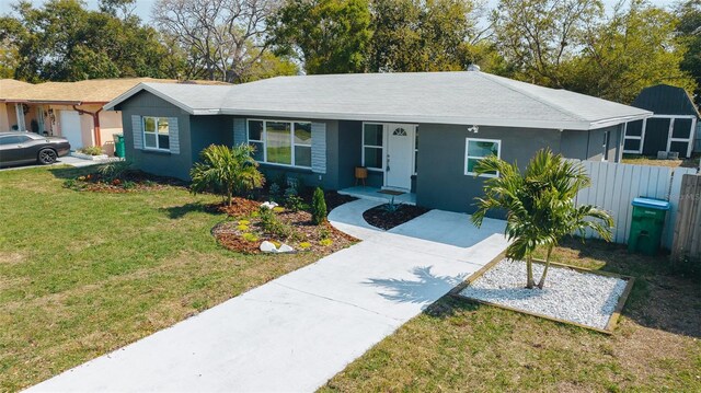 1605 Crown St, Clearwater, FL 33755 - ranch-style house featuring stucco siding, a front lawn, fence, and concrete driveway