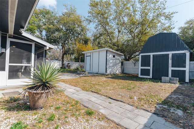 1605 Crown St, Clearwater, FL 33755 - view of yard with a sunroom, a fenced backyard, an outdoor structure, and a storage shed