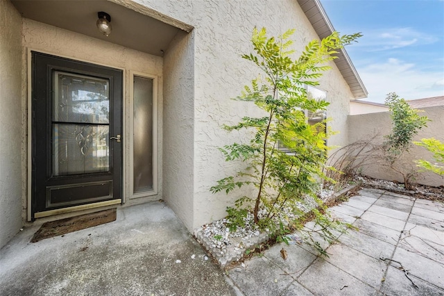 doorway to property featuring stucco siding