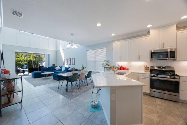 kitchen with visible vents, a sink, decorative backsplash, appliances with stainless steel finishes, and white cabinetry