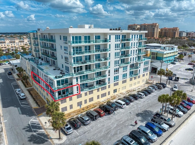 view of building exterior featuring a city view and uncovered parking