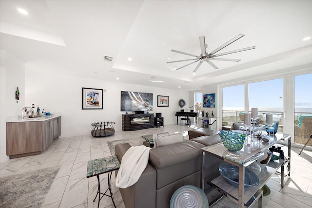 living room featuring visible vents, marble finish floor, a ceiling fan, a tray ceiling, and recessed lighting