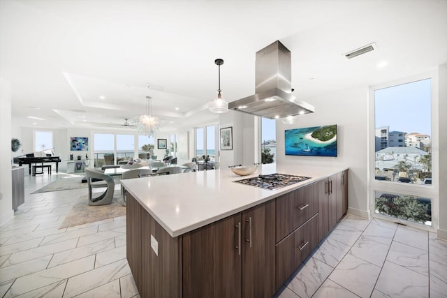 kitchen featuring visible vents, marble finish floor, modern cabinets, island exhaust hood, and stainless steel gas cooktop