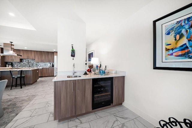 bar with beverage cooler, decorative backsplash, recessed lighting, marble finish floor, and a sink