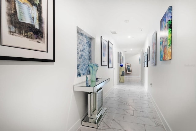 hall featuring recessed lighting, baseboards, and marble finish floor