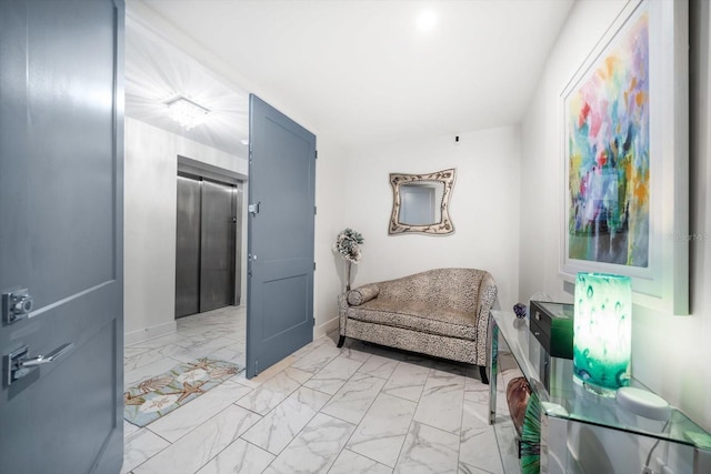 sitting room featuring baseboards, elevator, and marble finish floor