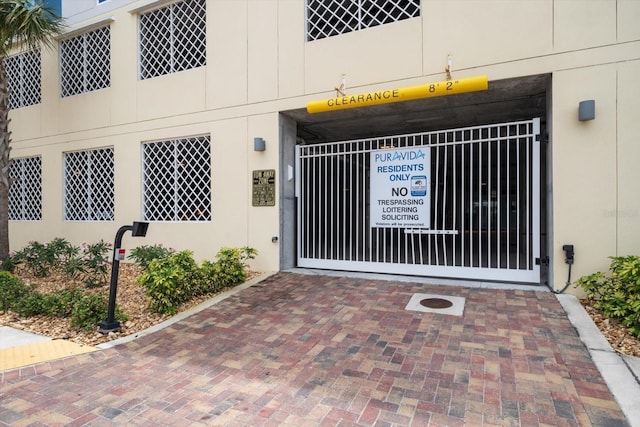 property entrance with stucco siding and a gate