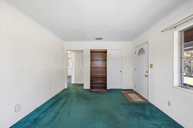 unfurnished room with visible vents and carpet flooring