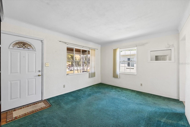 entrance foyer with baseboards and dark carpet