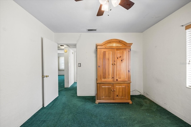 unfurnished bedroom featuring visible vents, ceiling fan, and dark carpet