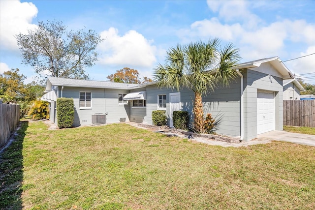 back of property featuring central air condition unit, a lawn, driveway, fence, and an attached garage