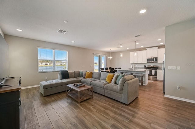 living area featuring baseboards, dark wood-style floors, visible vents, and recessed lighting