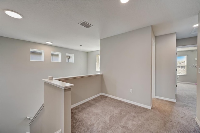 basement featuring baseboards, visible vents, and carpet flooring