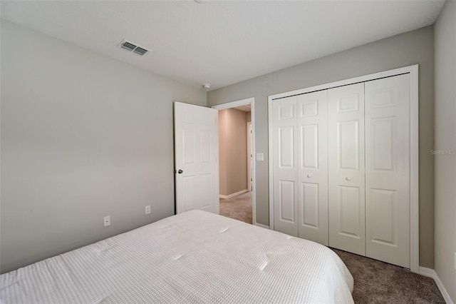 bedroom featuring a closet, carpet floors, visible vents, and baseboards