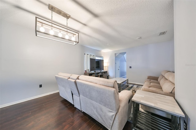 living area with visible vents, baseboards, a textured ceiling, and dark wood-style floors