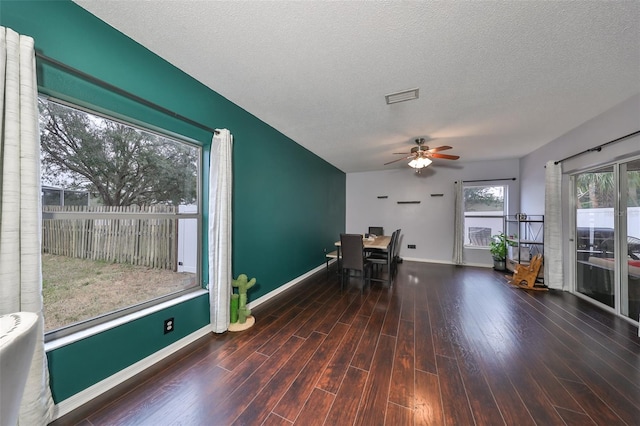 unfurnished office featuring visible vents, ceiling fan, baseboards, wood finished floors, and a textured ceiling