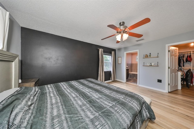 bedroom with baseboards, visible vents, ceiling fan, a spacious closet, and light wood-type flooring