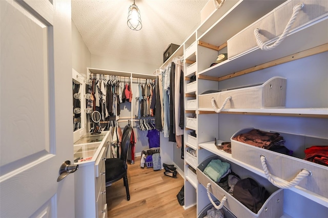 walk in closet with light wood-style floors