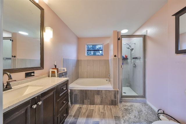 full bathroom featuring a bath, a stall shower, vanity, and wood tiled floor