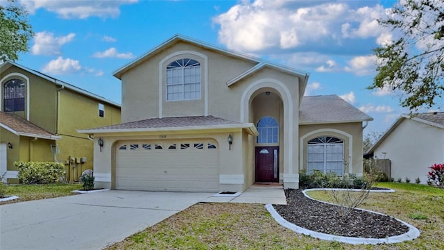 traditional-style house with stucco siding, driveway, fence, roof with shingles, and a garage