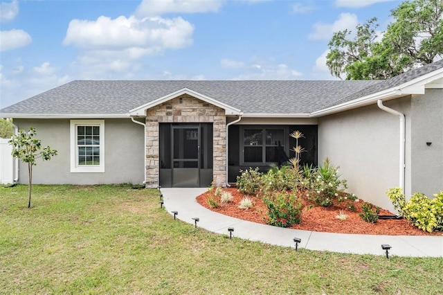 ranch-style house featuring a front yard, stone siding, roof with shingles, and stucco siding