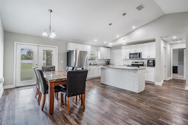 dining space with a wealth of natural light, visible vents, dark wood-style floors, and french doors