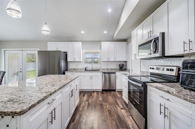 kitchen featuring dark wood-type flooring, a sink, white cabinetry, stainless steel appliances, and decorative backsplash